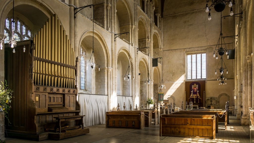 view inside Binham parish church including the organ, pews, and altar