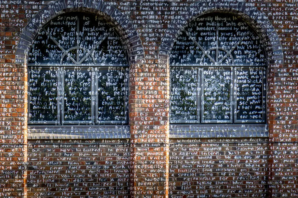 a section of the building in Norwich that has the text from the book Utopia written on it in white