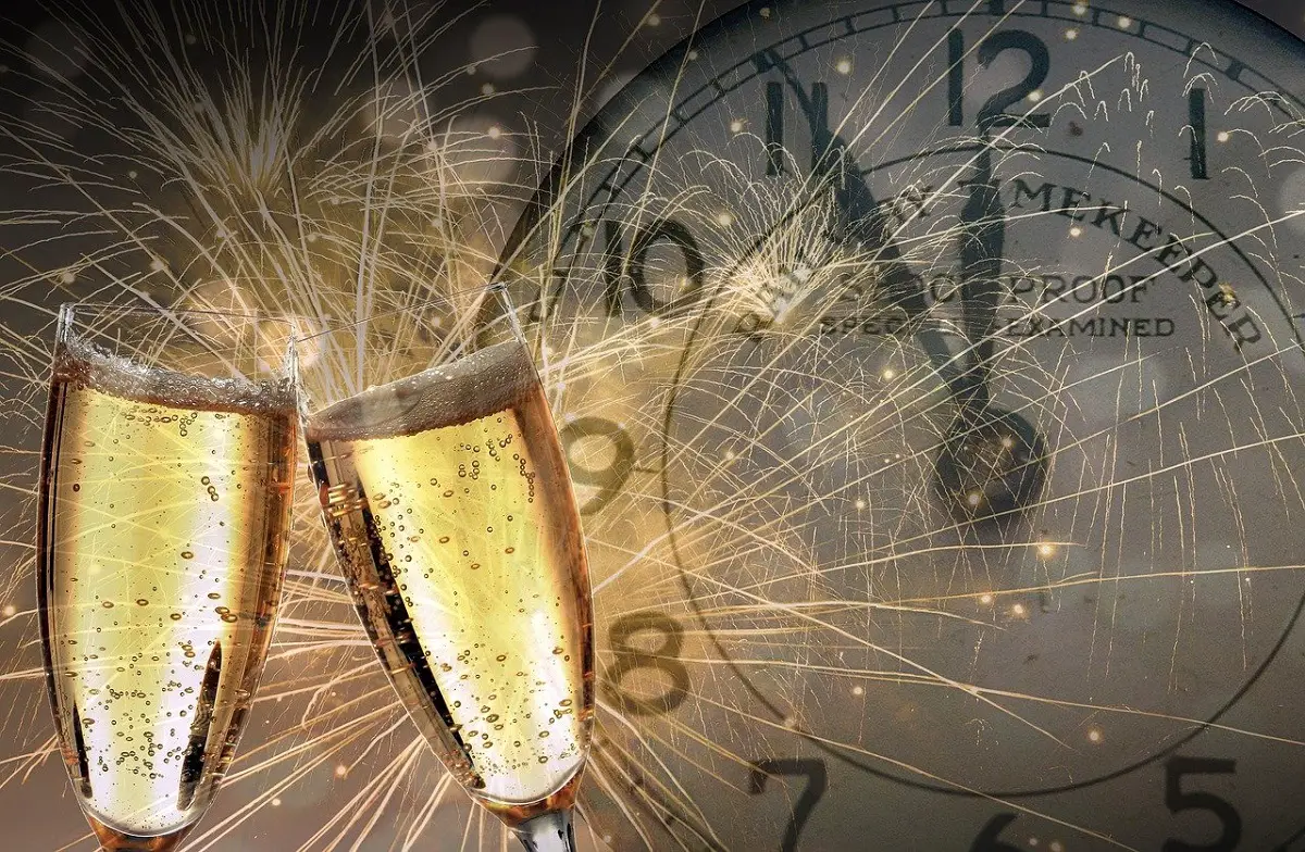 champagne glasses toasting as the clock ticks towards midnight on new year's eve