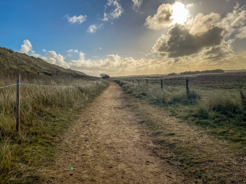 norfolk coast path near horsey with blue skies and a few clouds