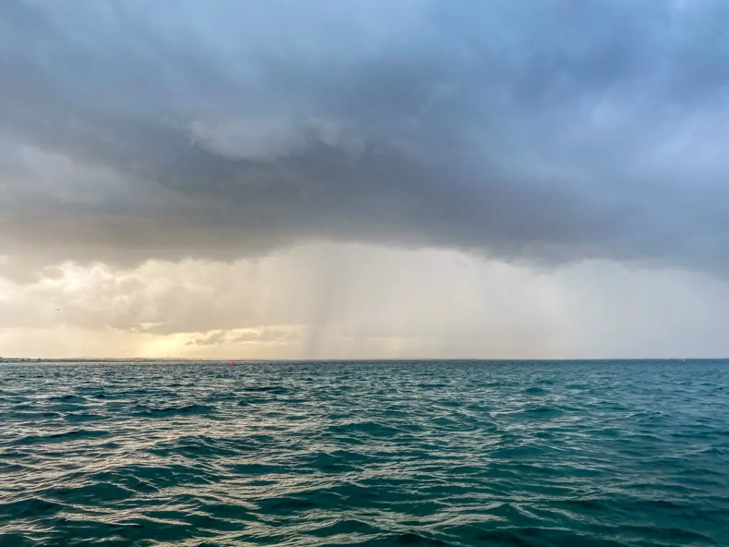 sea with rain clouds in the distance