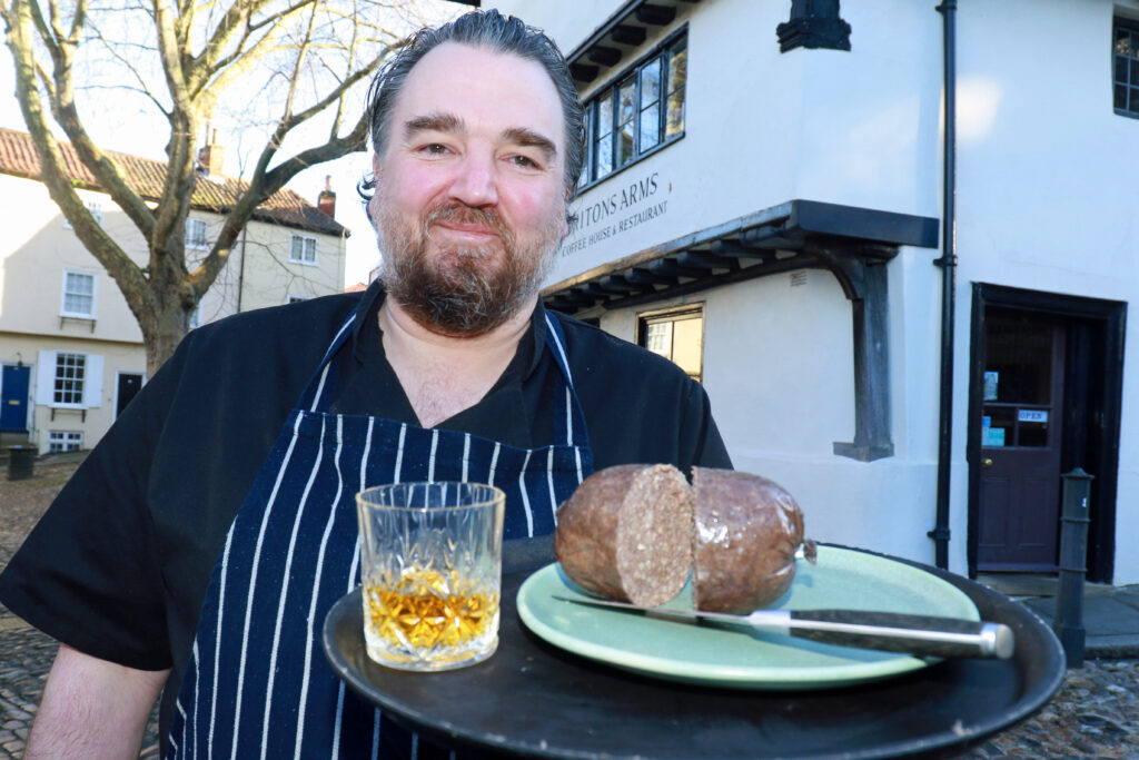 Richard Ellis from Britons Arms brandishing a glass of whisky and a haggis