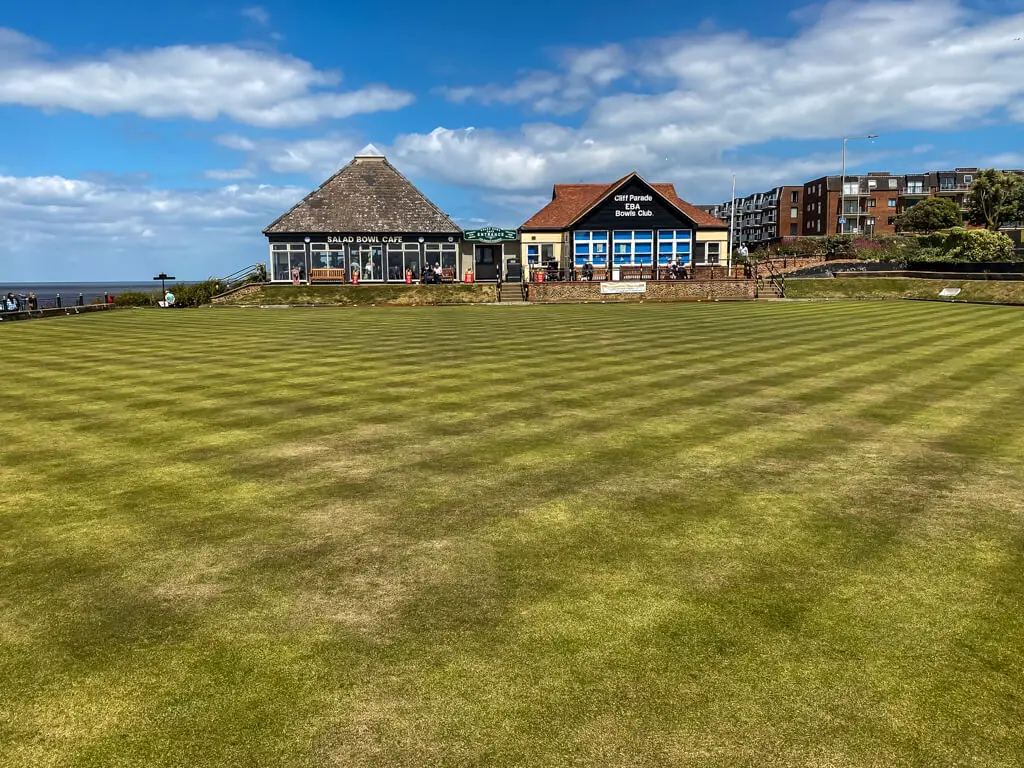 bowling green with two buildings in the distance