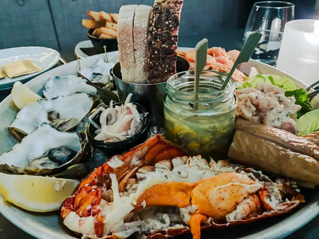 seafood platter - lobster, fish, shrimp, cockles, oysters, bread, lemon