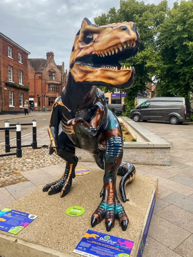 t-rex sculpture parts are painted futuristic and other parts are painted like a skeleton