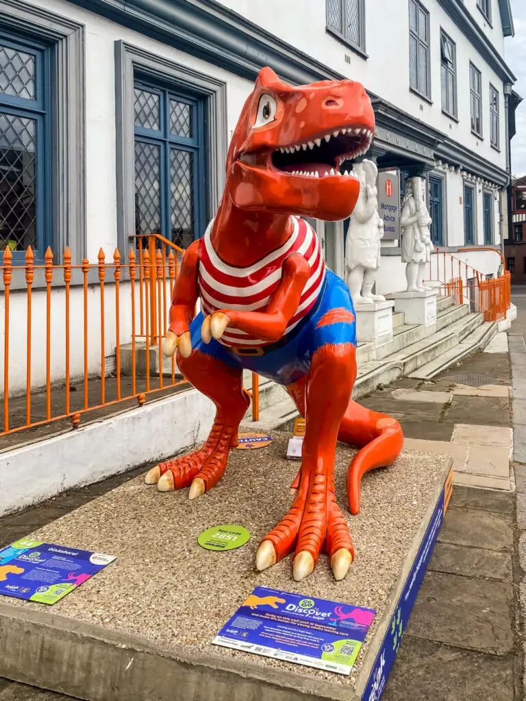 orange t-rex in a pirate outfit