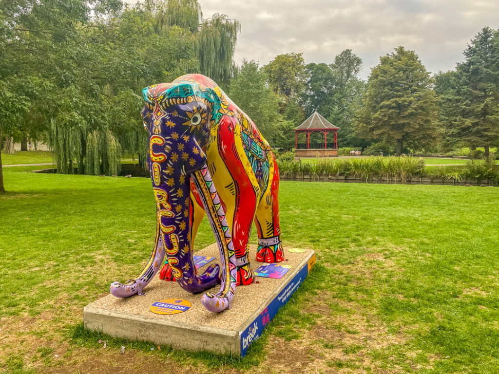 colourful mammoth with the word circus written on its trunk and the green grass of the Walks in the backgroundr