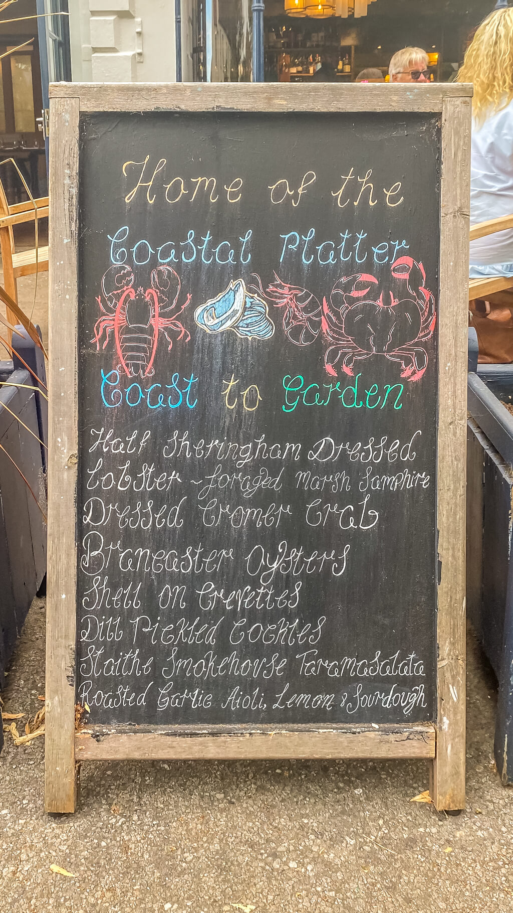 chalk board that list all the items that are pat of the Coastal Platter