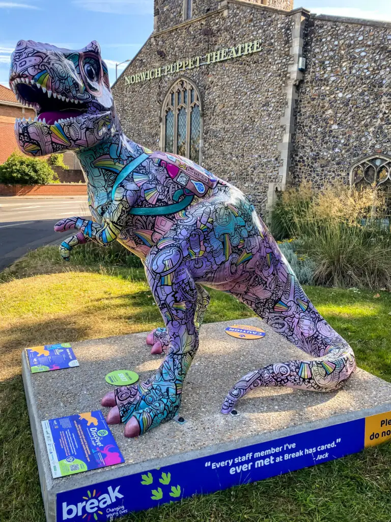 colorful dinosaur in front of church that is now norwich puppet theatre