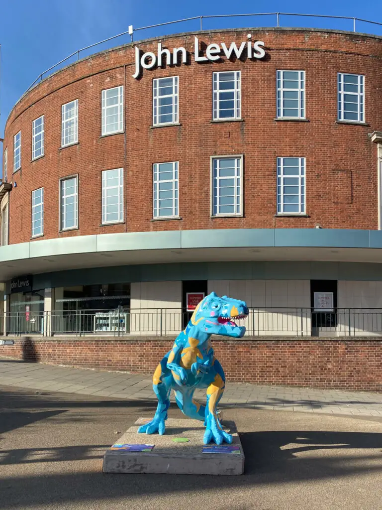 colourful t-rex in front of john lewis