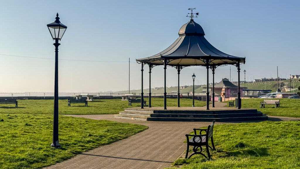 view of the gorleston band stand with a streetlight in front of it on a sunny day