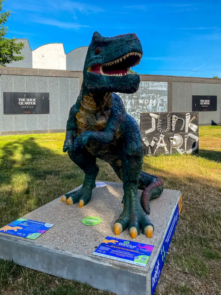 t-rex in front of the junkyard market sign