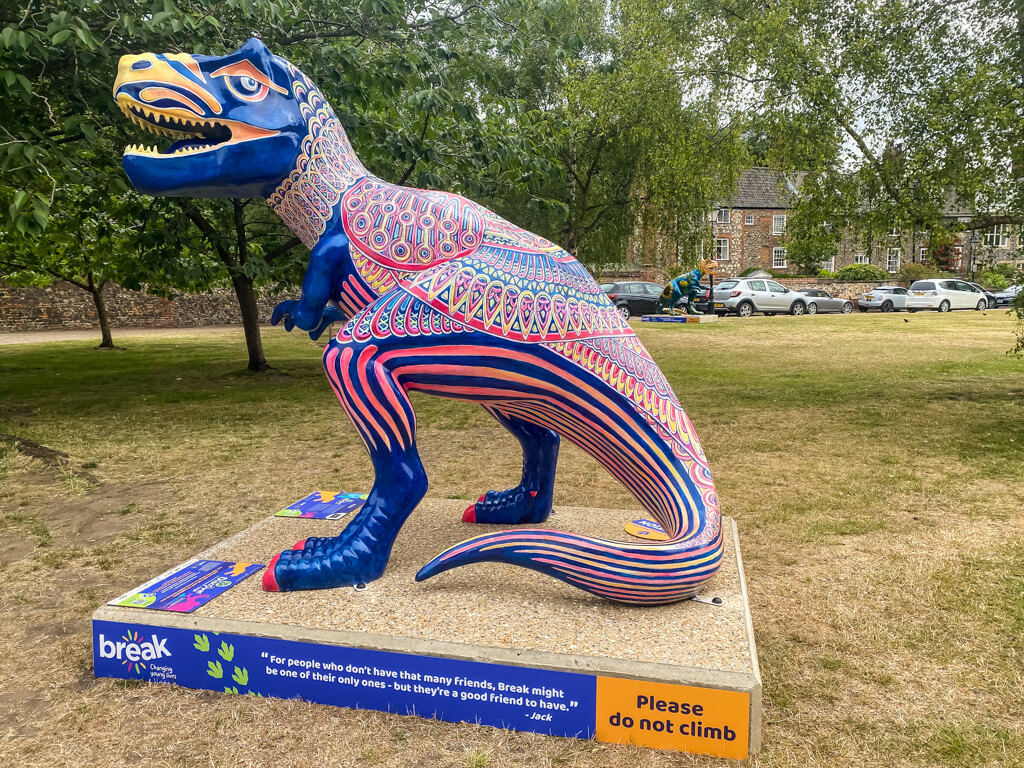 t-rex sculpture with a colourful intricate pattern painted on it
