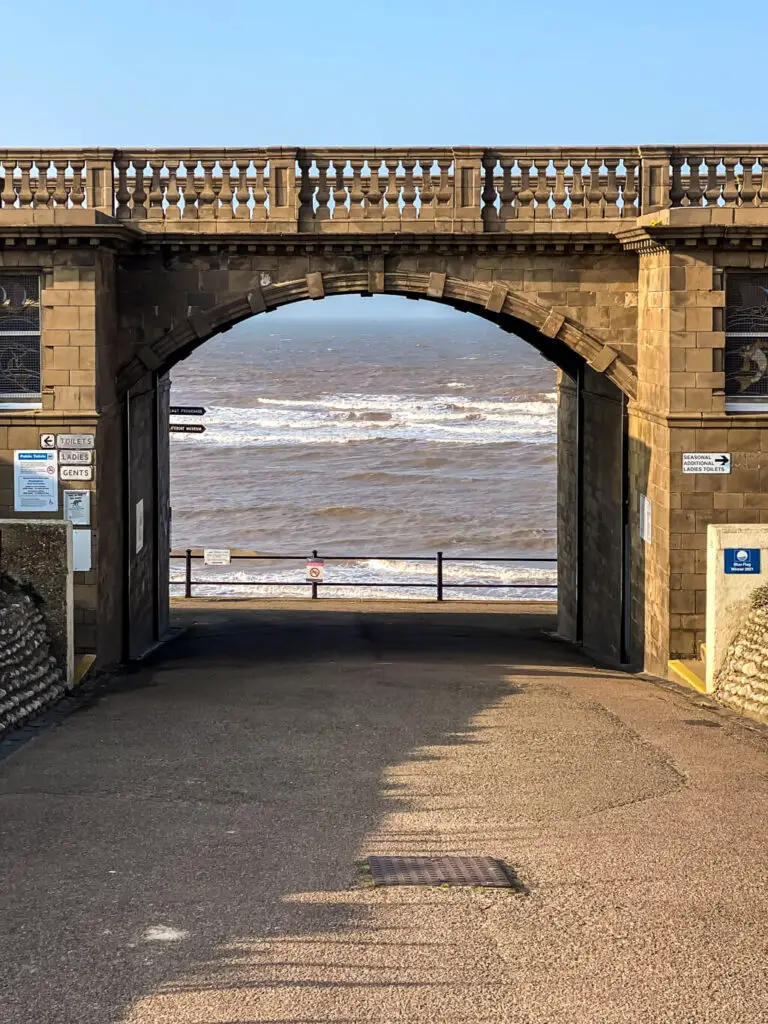 view through arch bridge in sheringham where you can see the sea with waves
