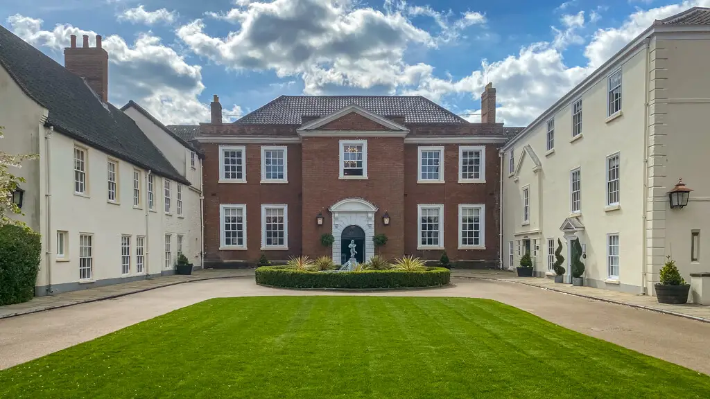 exterior of the assembly house with grass and fountain in front