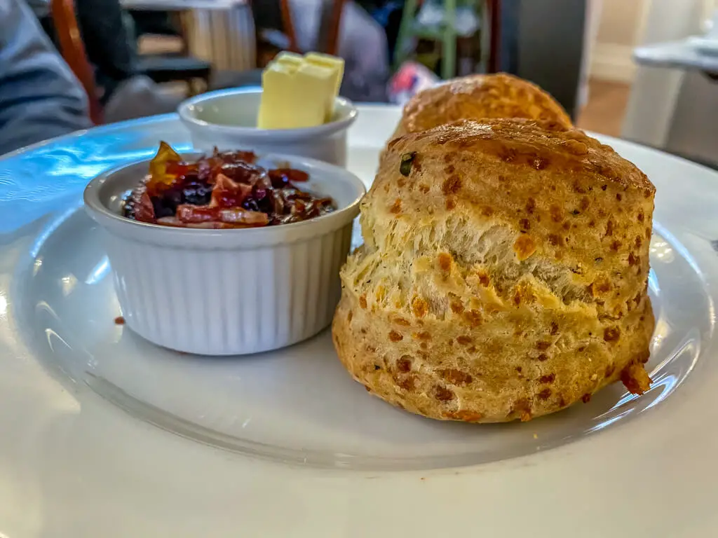 scone with white ramekin of bacon jam and white ramekin of butter