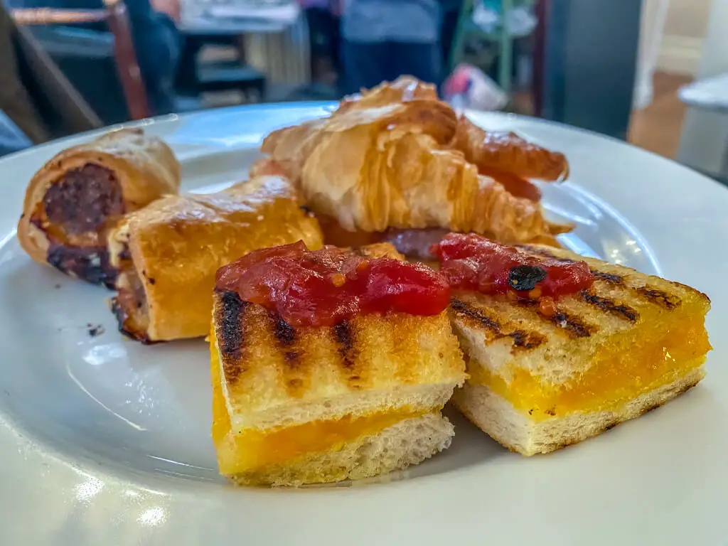 the selection of savoury treats - sausage rool, croissant with salmon, and cheese toastie (2 of each)