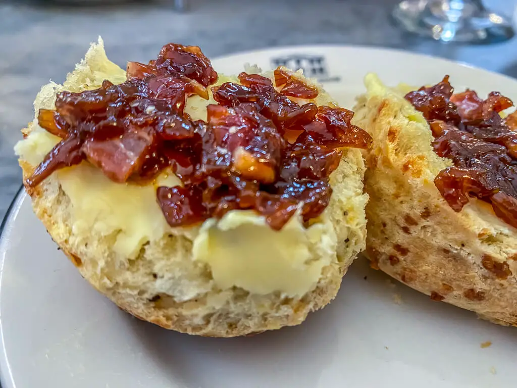 close up of scone with butter and bacon jam