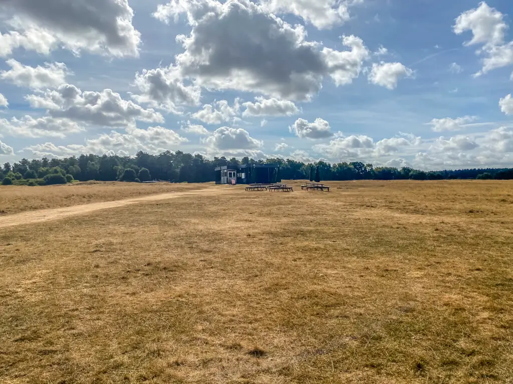 view of Grimes Graves visitor centre and picnic tables at grimes graves from a distance