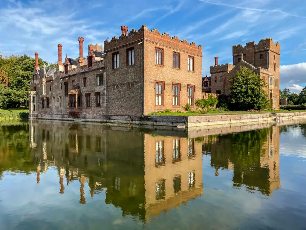 oxburgh hall surrounded by a moat with reflection