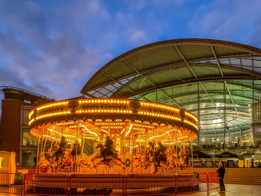 old carousel lit up in front of the forum in Norwich