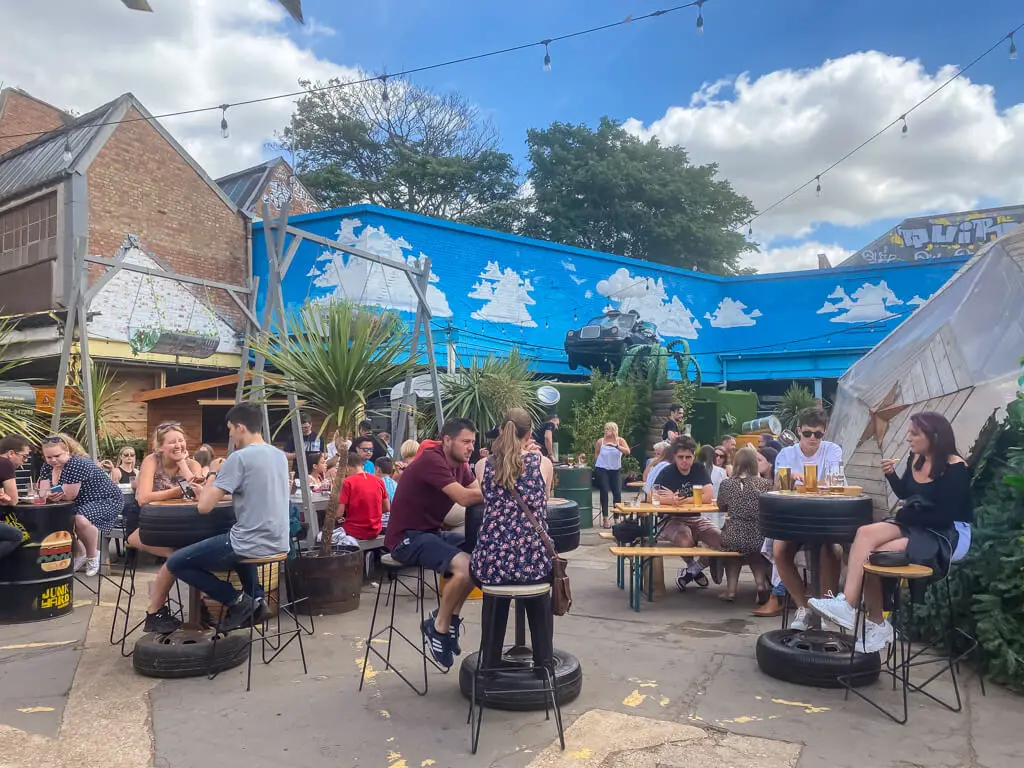 some of the outdoor tables with people at junkyard market