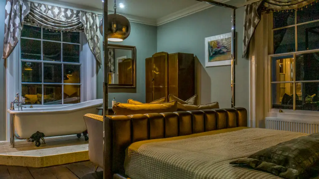 the gurney room at the old post office in norfolk, you can see the foot of the large bed and the bathtub by the window