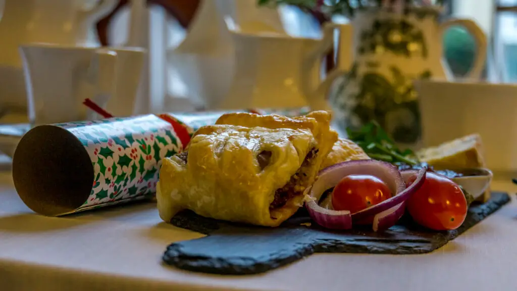 selection of savoury items with afternoon tea - sausage roll & vegetables are visible