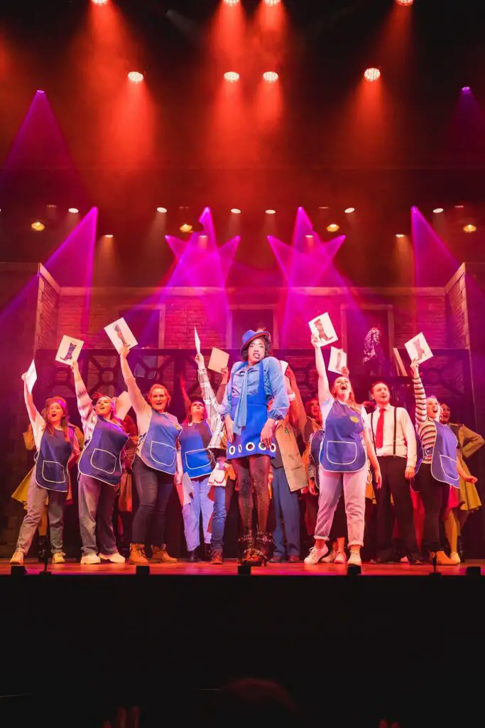 cast holding up pictures of Kinky Boots