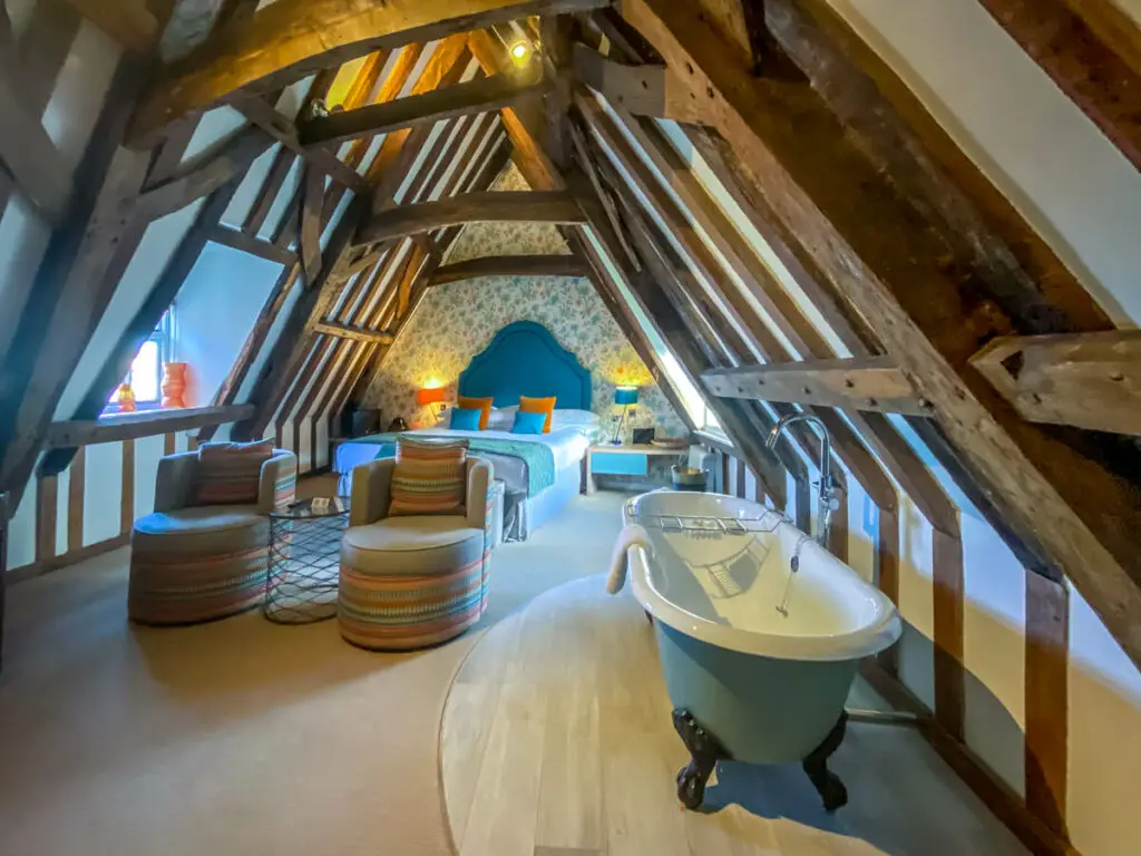 room with exposed beams and a roll top bathtub