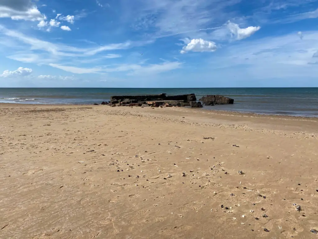 Titchwell beach sand with a view of ruins at the shoreline