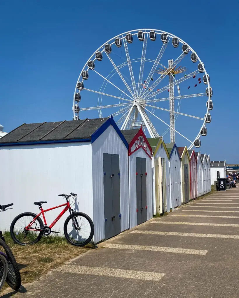 beach huts on the promenade in great yarmouth with the great yarmouth eye in the background