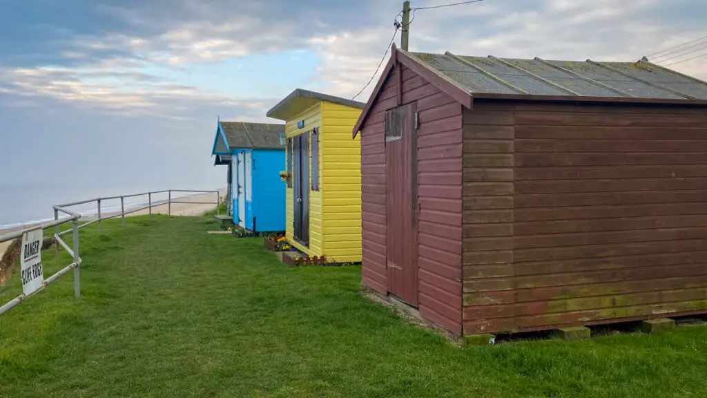 three of the beach huts on top of the cliff at scratby beach in norfolk