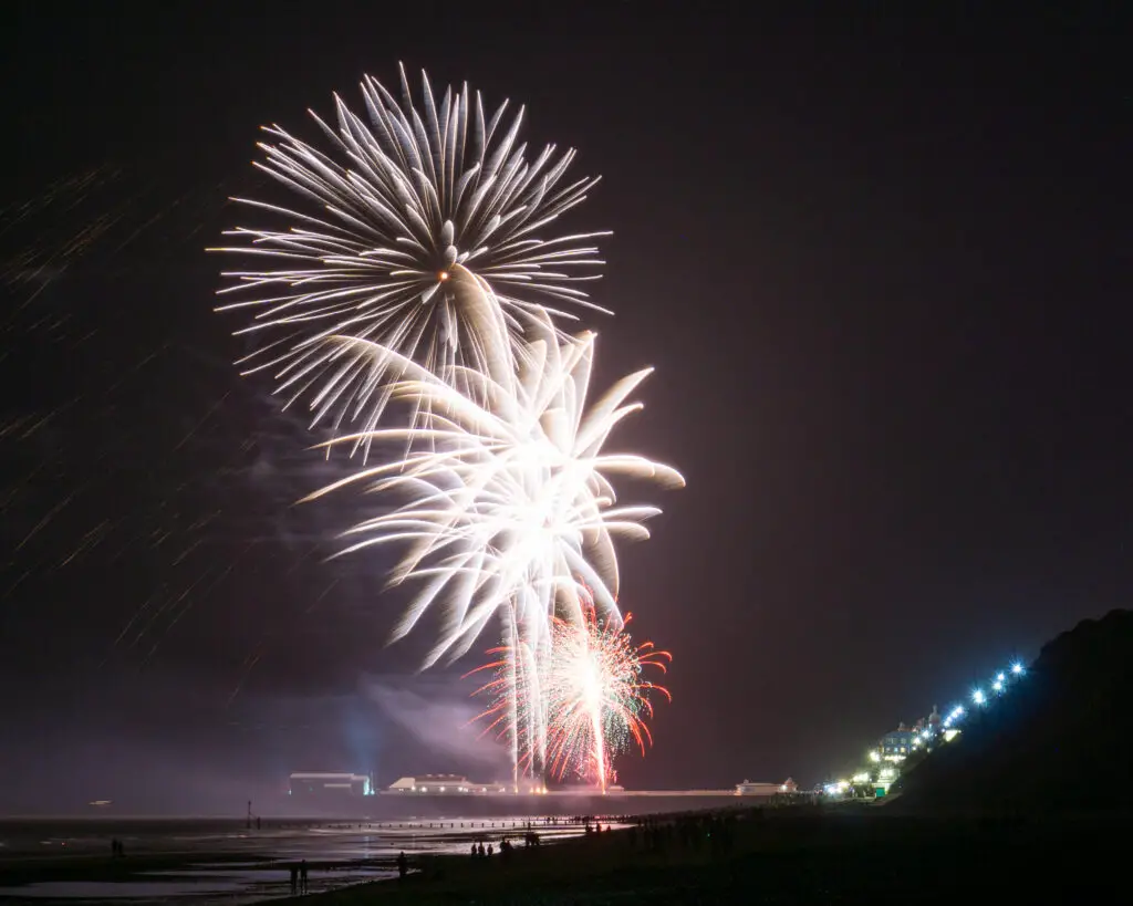 white fireworks exploding over the pier in Cromer